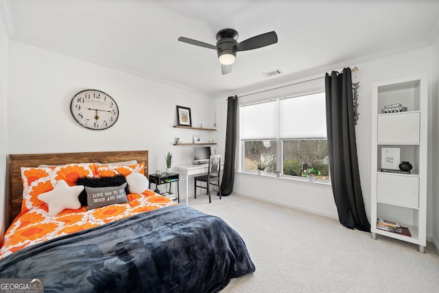 carpeted bedroom featuring ornamental molding, a ceiling fan, visible vents, and baseboards