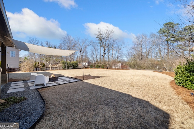 view of yard featuring a fire pit, a patio, and fence