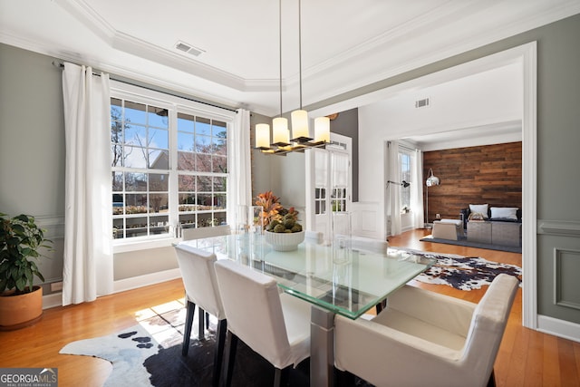 dining area featuring ornamental molding, light wood finished floors, plenty of natural light, and visible vents