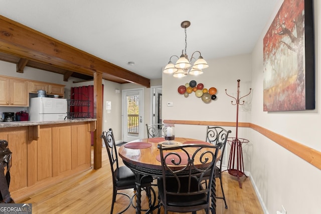 dining room featuring baseboards, a chandelier, beam ceiling, and light wood-style floors