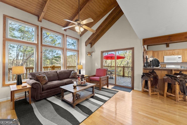 living area with light wood-type flooring, beamed ceiling, and baseboards