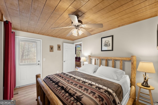 bedroom with wooden ceiling, multiple windows, and wood finished floors
