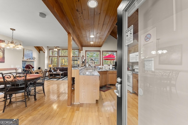 kitchen featuring white appliances, a large fireplace, open floor plan, beamed ceiling, and light wood-style floors