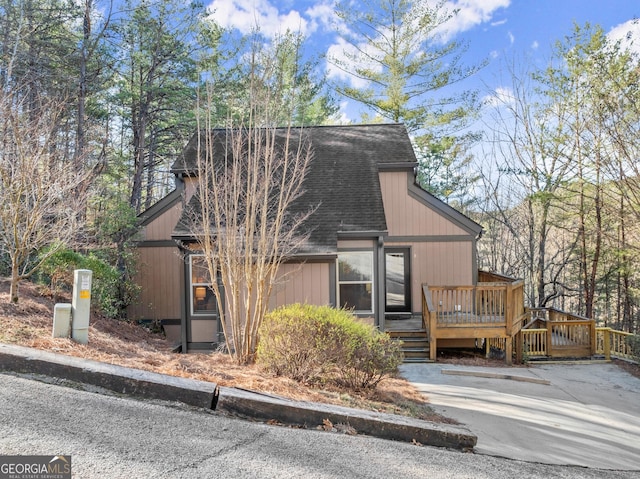 view of front of home featuring a shingled roof and a wooden deck