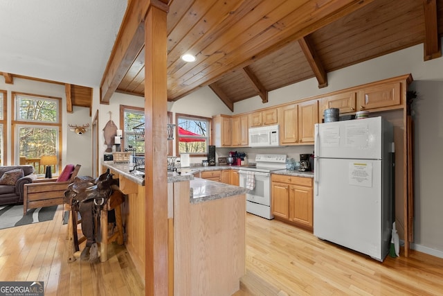 kitchen featuring vaulted ceiling with beams, a peninsula, white appliances, and light wood-style floors
