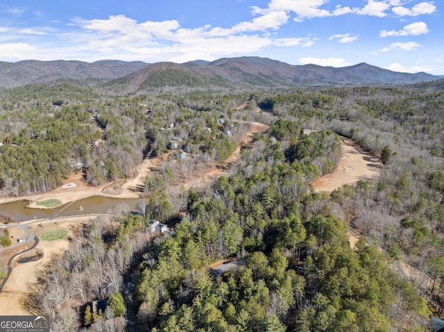 birds eye view of property featuring a wooded view and a water and mountain view