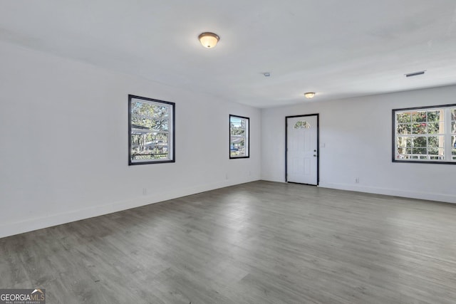 spare room with visible vents, baseboards, and wood finished floors