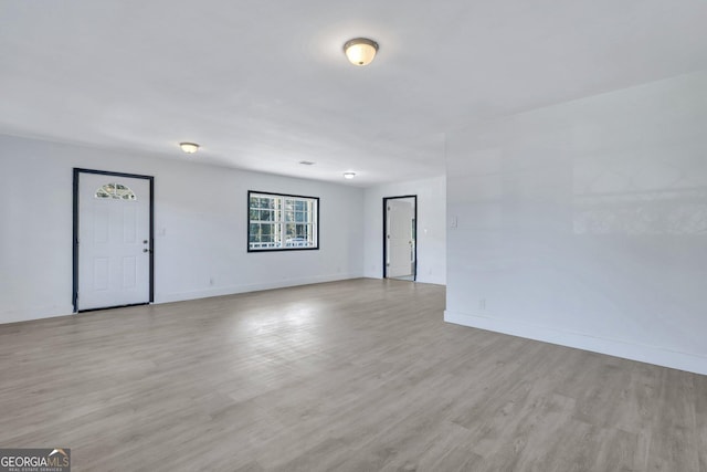 spare room featuring light wood finished floors and baseboards