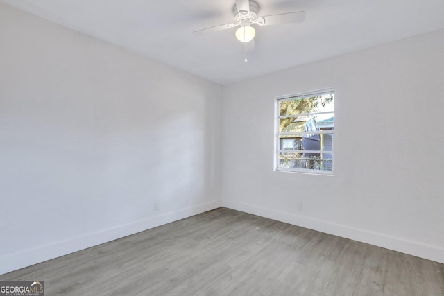 unfurnished room featuring ceiling fan, wood finished floors, and baseboards