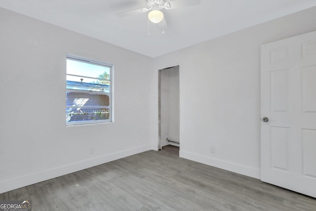 unfurnished bedroom with a ceiling fan, baseboards, and wood finished floors