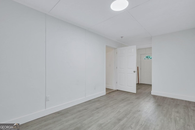 spare room featuring baseboards and wood finished floors