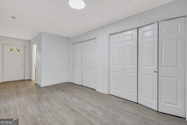 foyer entrance featuring light wood-type flooring and baseboards