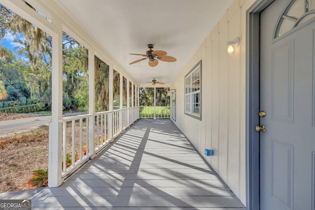 unfurnished sunroom featuring a ceiling fan