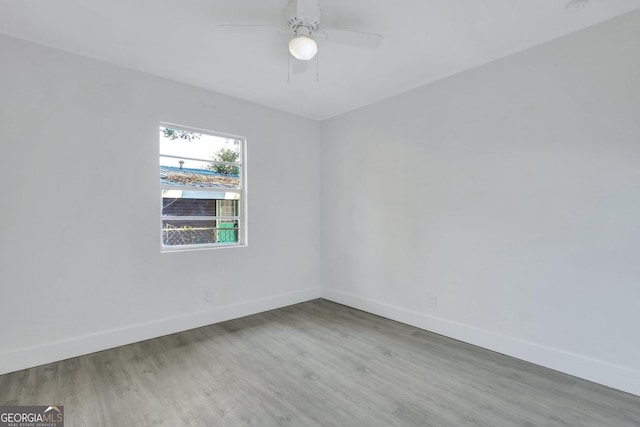 empty room featuring ceiling fan, wood finished floors, and baseboards