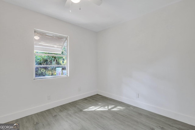 empty room featuring a ceiling fan, baseboards, and wood finished floors