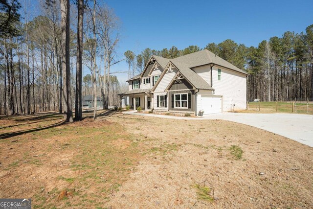 view of front of property featuring board and batten siding, a front yard, concrete driveway, and an attached garage