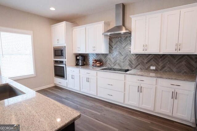 kitchen with white cabinets, wall chimney range hood, stainless steel appliances, and backsplash