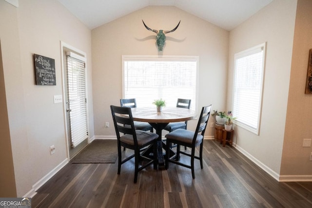 dining space with vaulted ceiling, baseboards, and dark wood finished floors