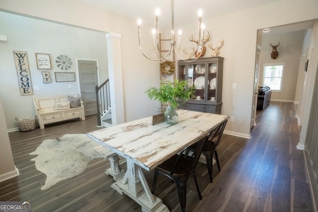 dining area with dark wood-type flooring, a notable chandelier, stairway, and baseboards