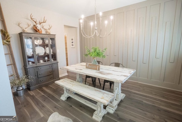dining space featuring dark wood-style flooring and an inviting chandelier
