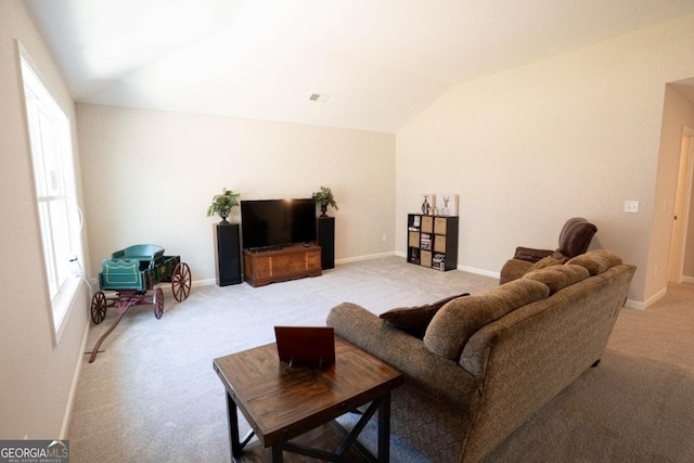 living room with baseboards, vaulted ceiling, and light colored carpet