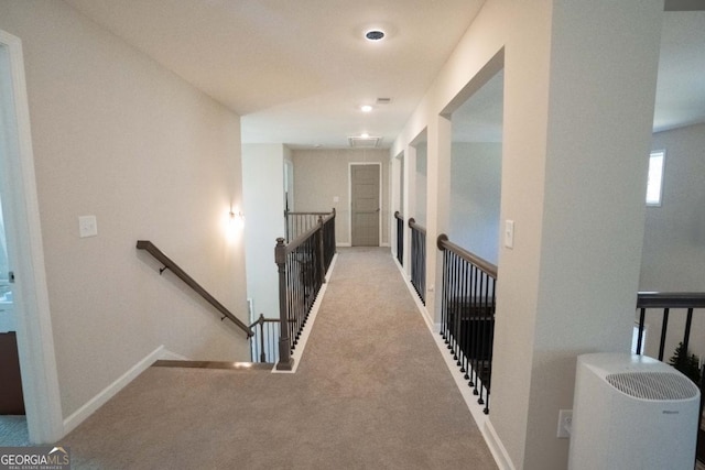 corridor featuring carpet floors, an upstairs landing, and baseboards