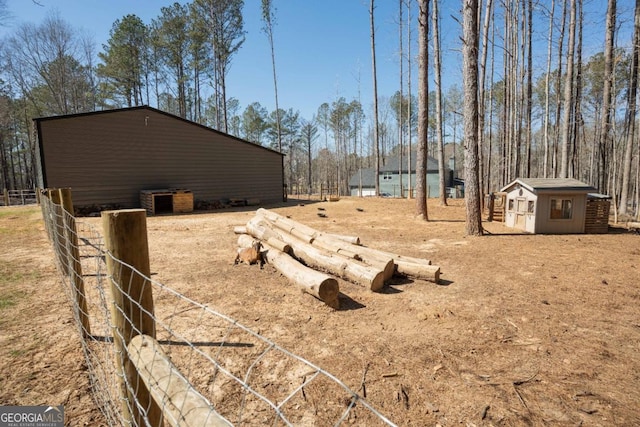 view of yard with fence and an outdoor structure