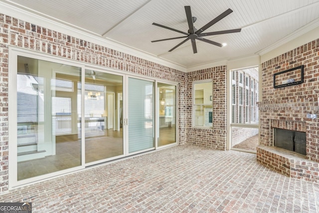 unfurnished sunroom featuring an outdoor brick fireplace and a ceiling fan