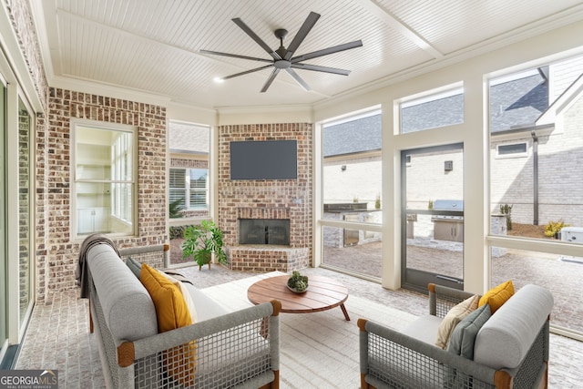 sunroom / solarium featuring an outdoor brick fireplace, plenty of natural light, and ceiling fan