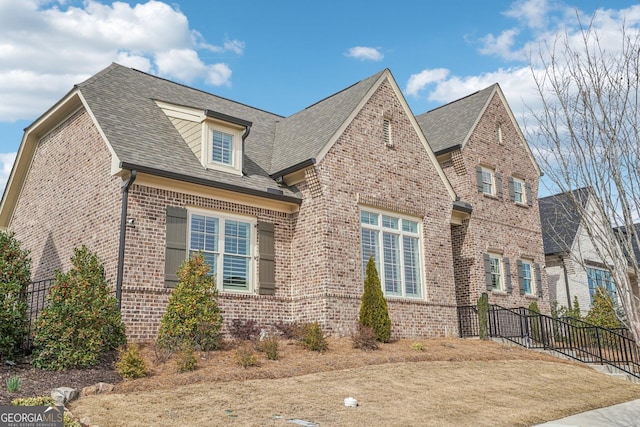 view of front of property featuring brick siding and a shingled roof