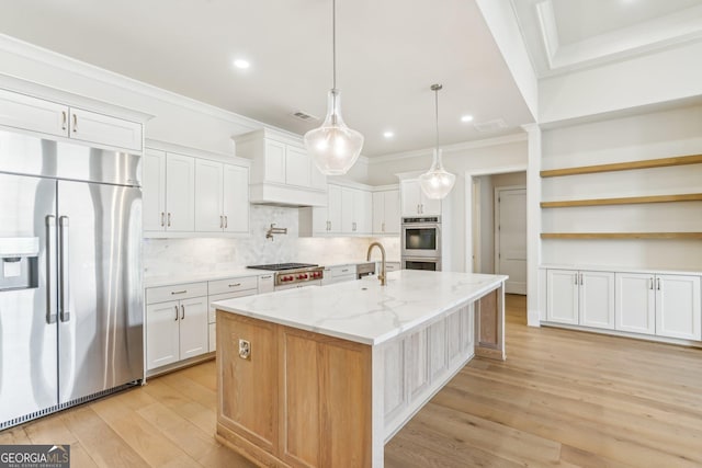 kitchen featuring premium range hood, ornamental molding, appliances with stainless steel finishes, light wood-type flooring, and tasteful backsplash