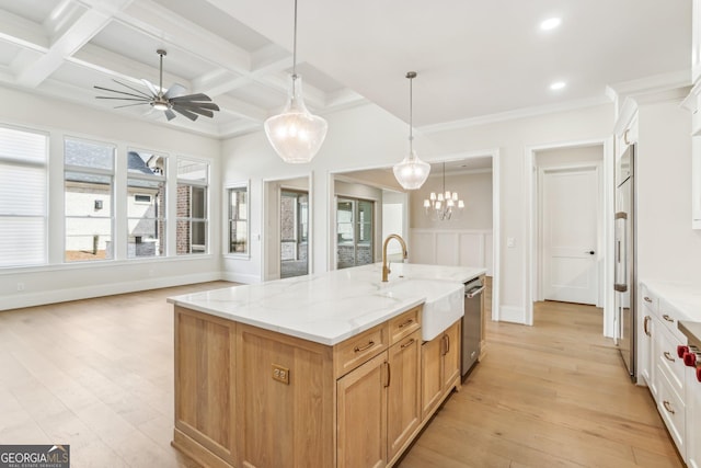 kitchen with light wood-style floors, coffered ceiling, a sink, and light stone countertops