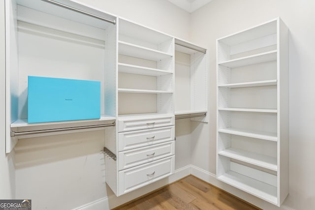 walk in closet featuring built in study area and light wood-style flooring