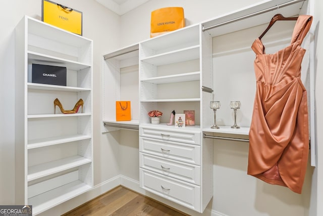 walk in closet with wood finished floors