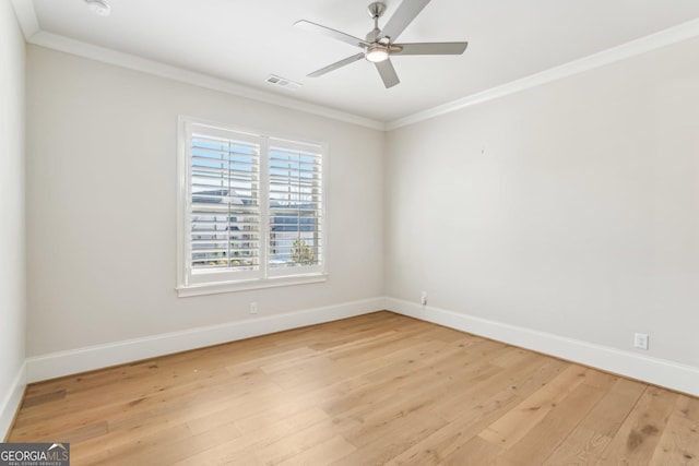 unfurnished room featuring a ceiling fan, visible vents, baseboards, ornamental molding, and light wood-type flooring