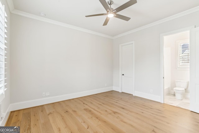 unfurnished bedroom featuring ensuite bathroom, ornamental molding, ceiling fan, wood finished floors, and baseboards