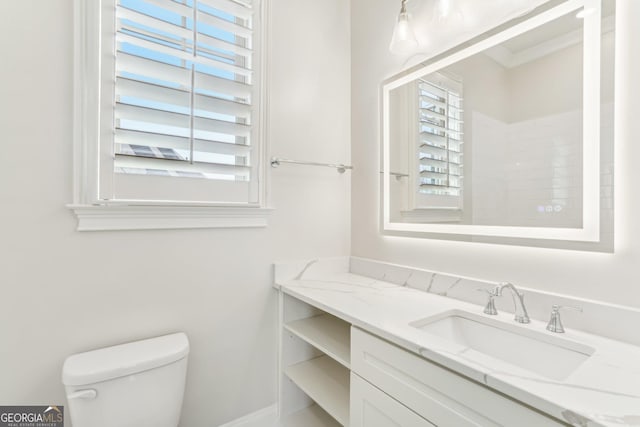 bathroom featuring toilet, plenty of natural light, and vanity