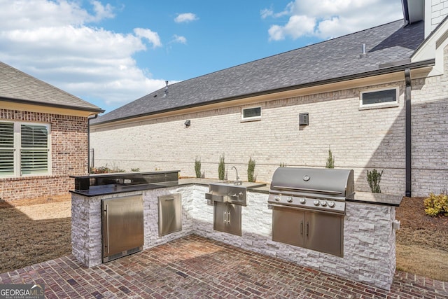 view of patio / terrace with a sink, grilling area, and exterior kitchen