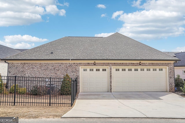 view of side of home with driveway, roof with shingles, an attached garage, fence, and brick siding