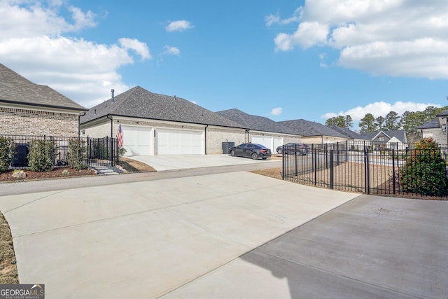 view of side of property with a garage, concrete driveway, and fence