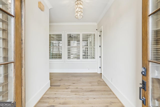 hallway featuring crown molding, light wood-style flooring, and baseboards