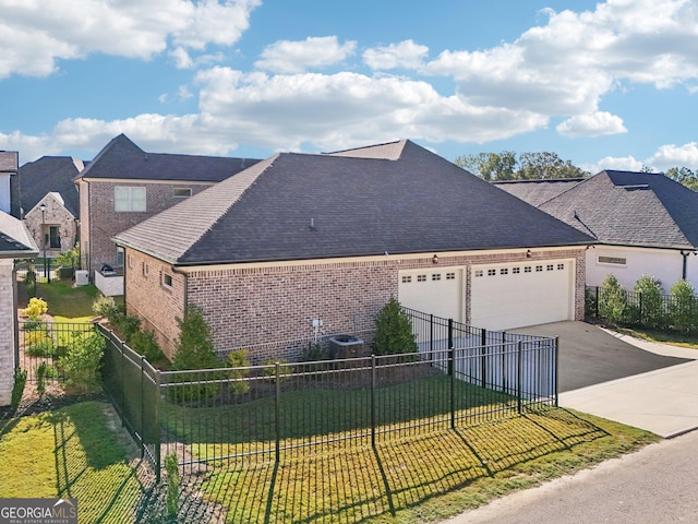 view of home's exterior featuring brick siding, concrete driveway, a lawn, fence, and a garage