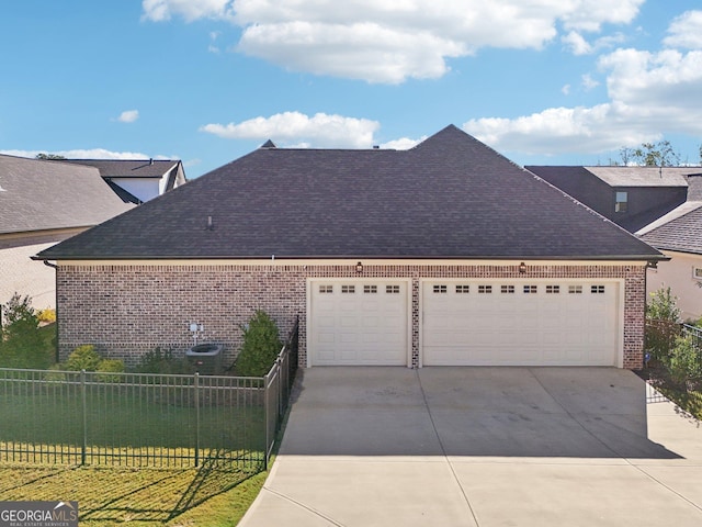 view of front facade with a shingled roof, concrete driveway, an attached garage, fence, and brick siding