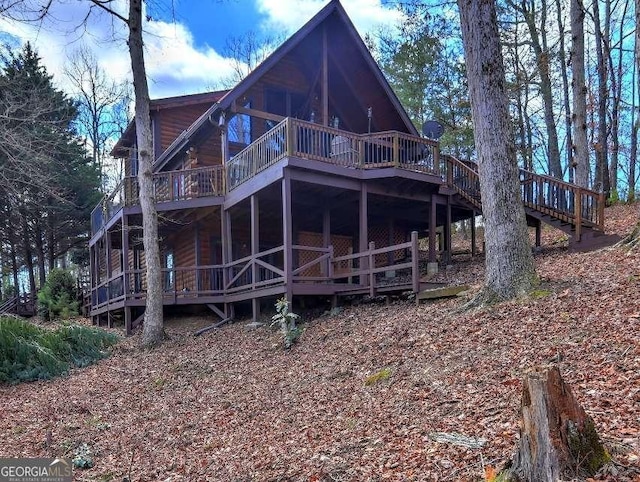 back of property featuring log veneer siding and a wooden deck