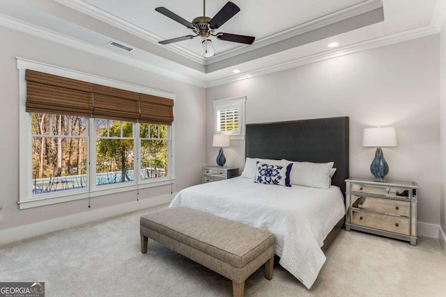 carpeted bedroom with ornamental molding, a tray ceiling, visible vents, and baseboards