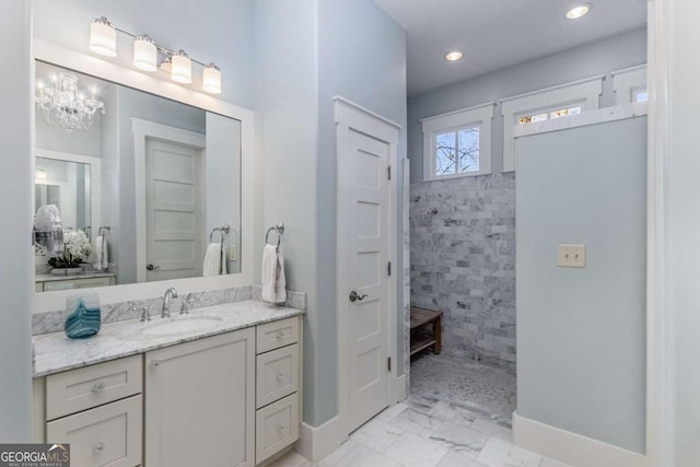 bathroom with marble finish floor, recessed lighting, vanity, a walk in shower, and baseboards