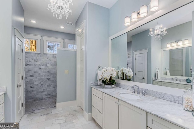 bathroom with marble finish floor, visible vents, an inviting chandelier, vanity, and walk in shower