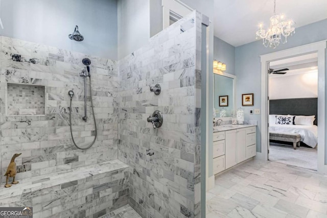 full bathroom with connected bathroom, vanity, marble finish floor, a tile shower, and an inviting chandelier