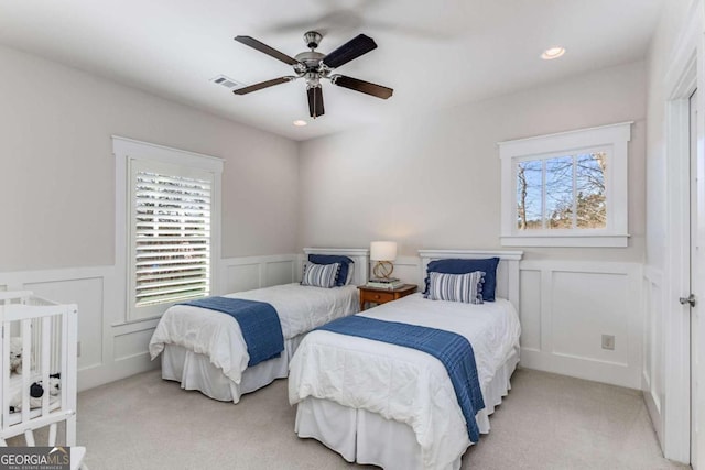 bedroom featuring carpet, visible vents, and a decorative wall