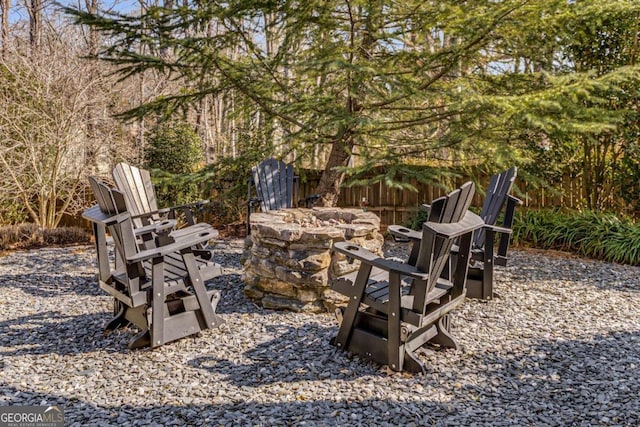 view of yard featuring a patio, an outdoor fire pit, and fence